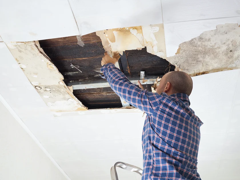 man repairing collapsed ceiling